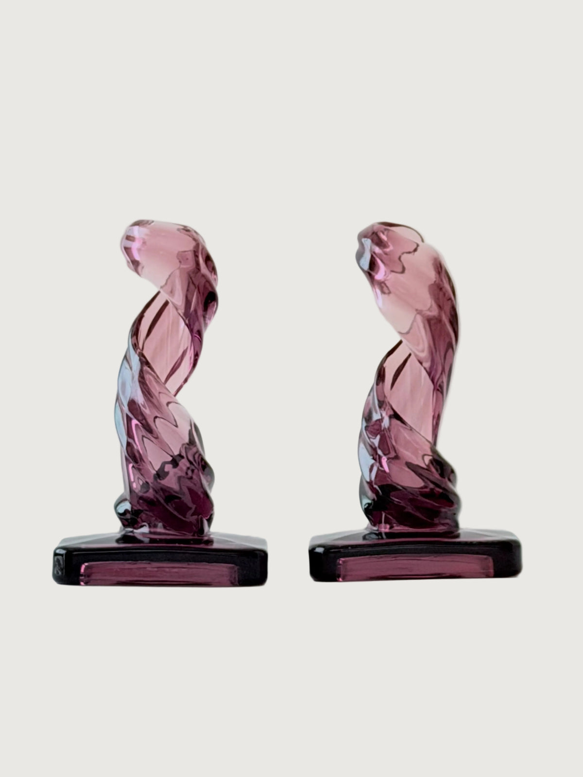 A pair of purple twisted glass candleholders.