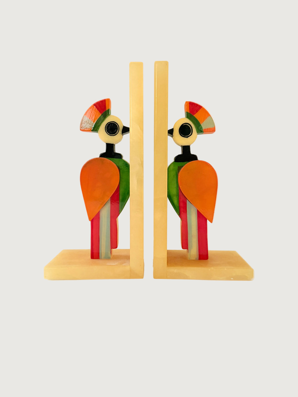 A pair of colorful alabaster bookends shaped like stylized birds set against a plain white background. Home Decor. Vintage. Collectible. 