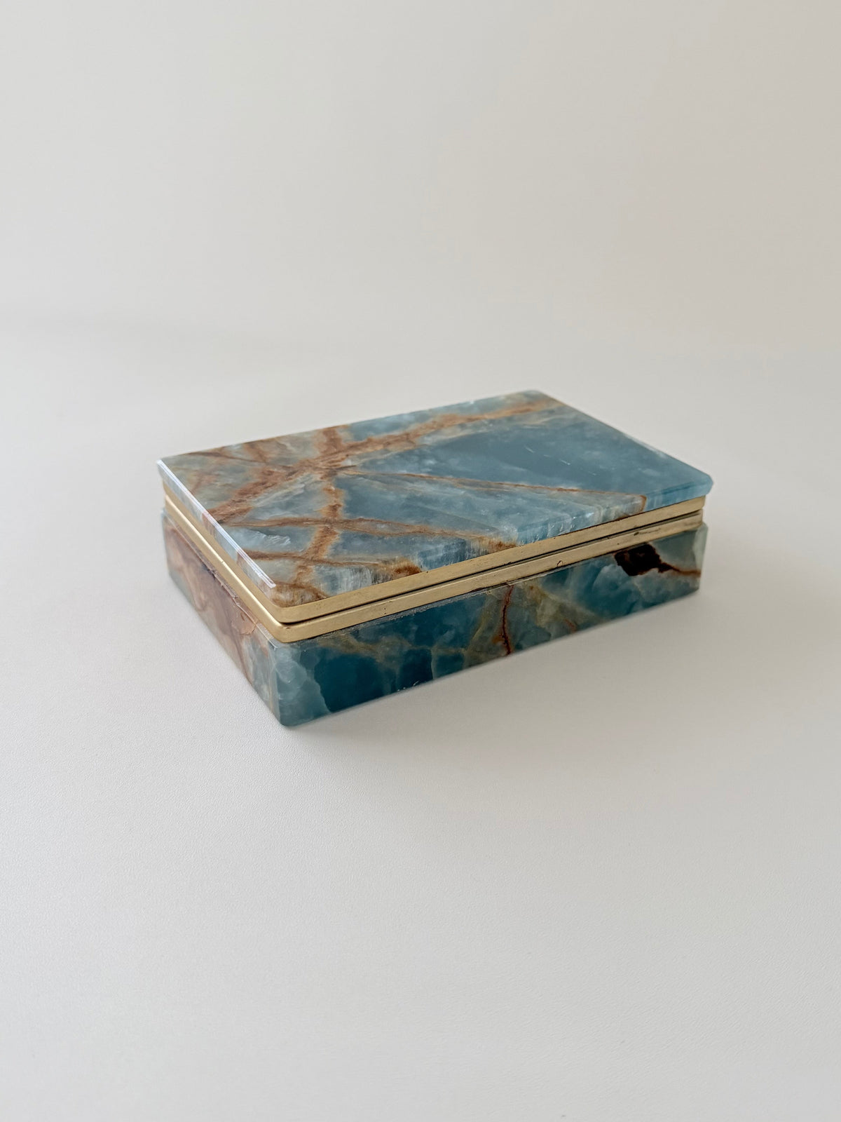 Closed Luxurious blue onyx vintage box with rust color veining and brass hinges. From Italy and made between 1950s and 1970s and comes with its original G.S.E. Ottone Garantito sticker. Home Decor. Vintage. Collectible. 