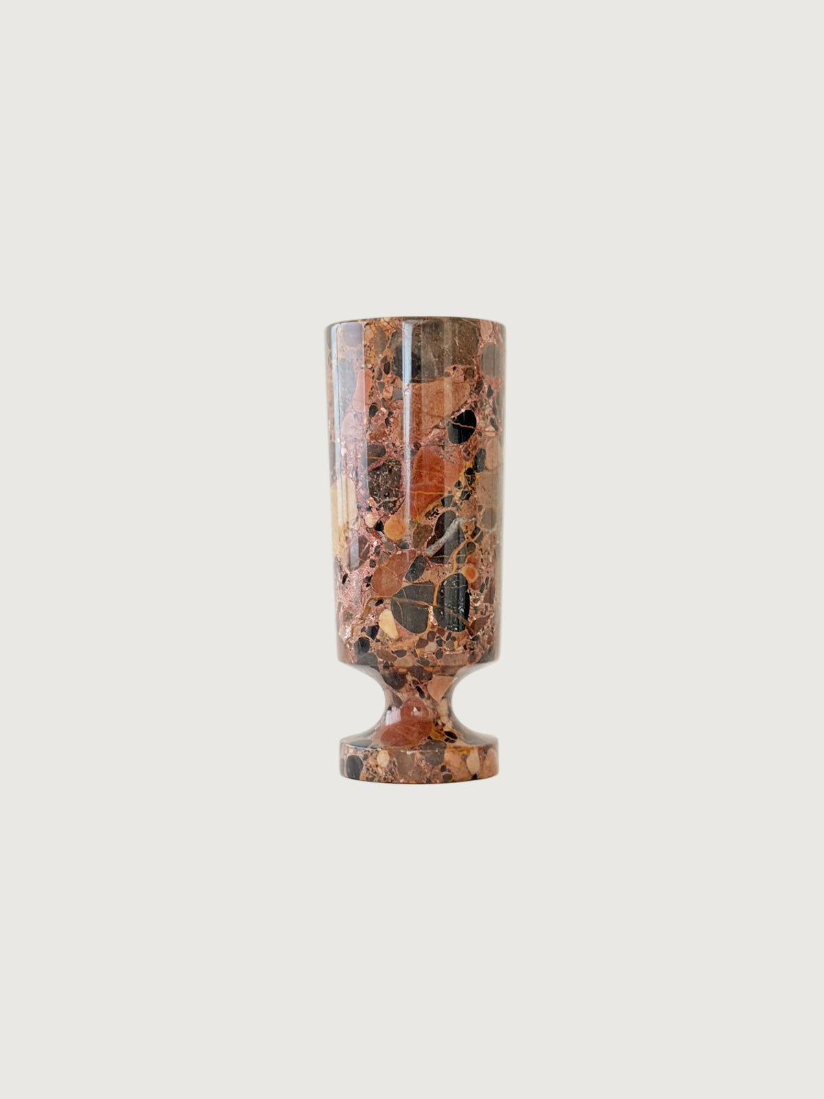 A breccia marble cylindrical vase  with a natural earth-toned stone featuring a fragmented, multicolored "brecciated" look and veining.