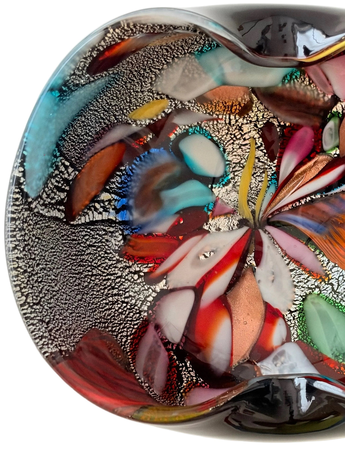 A striking mid-century hand-formed Murano "Tutti Frutti" bowl with two soft folds on thick black glass, a form used for bowls and ashtrays. Inside are bold colored fragments, cane sections on silver leaf and aventurine, copper crystals that make the glass sparkle.