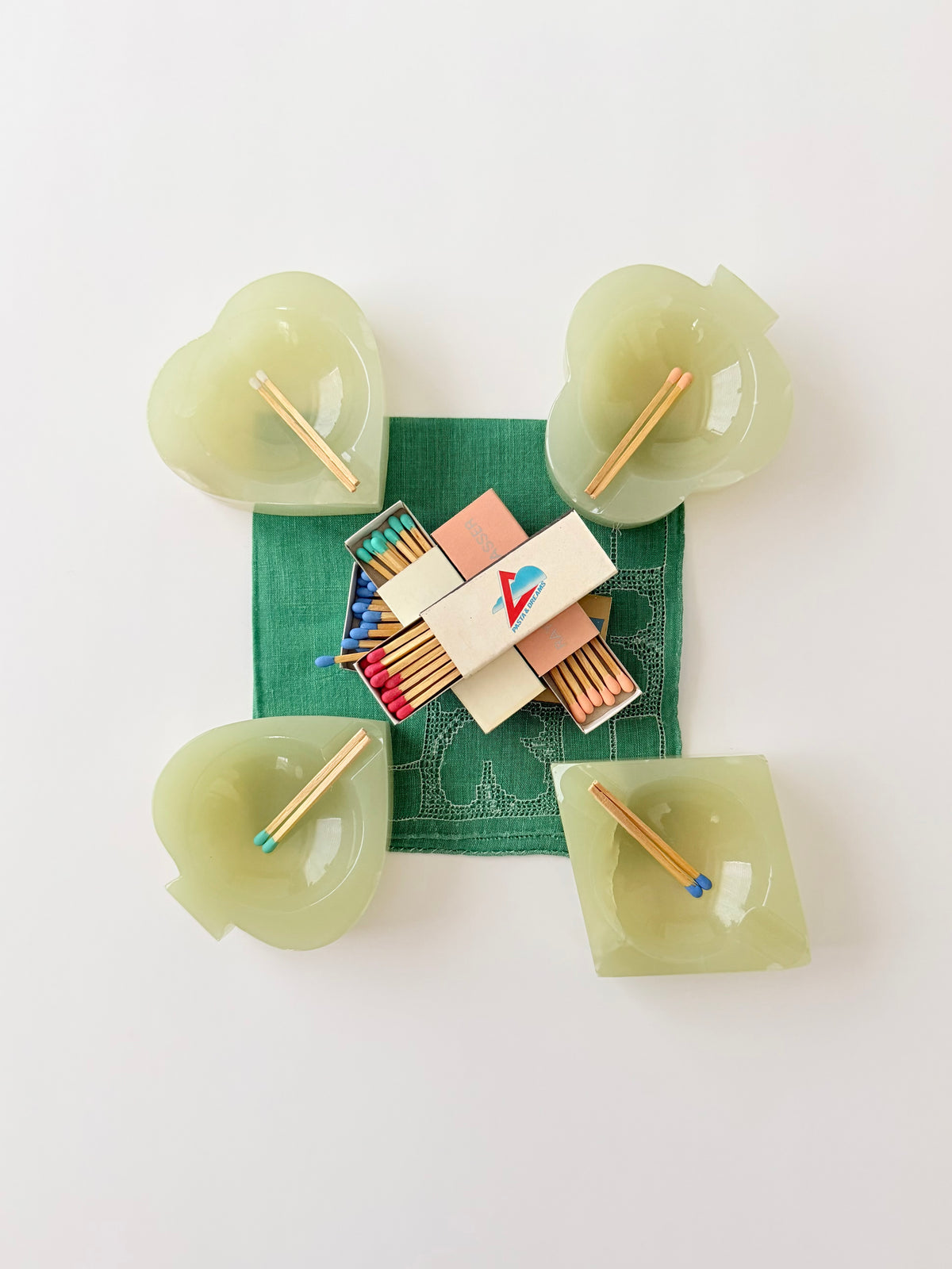 Set of 4 light green onyx ashtrays bridge set styled with matches on a green handkerchief.