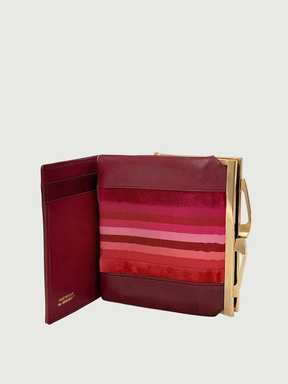 A burgundy leather wallet with a gold-tone metal frame and handle, shown open.